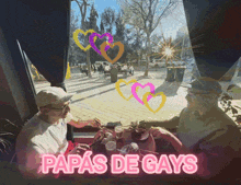 a sign that says papas de gays shows a couple sitting at a table