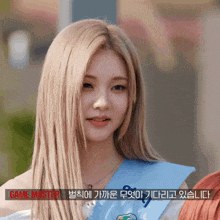 a woman with long blonde hair is wearing a blue sash that says game master on it