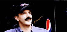 a man wearing a pepsi max hat has a fake mustache on his face