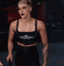 a woman with a tattoo on her arm is wearing a black top