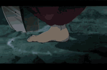a close up of a person 's foot with a large knife in the background