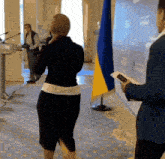 a woman in a black skirt is standing next to a man in a blue suit