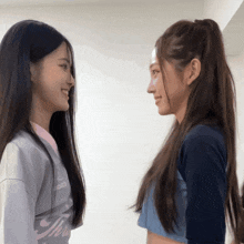 two girls are looking at each other with one wearing a shirt that says mizuno on it