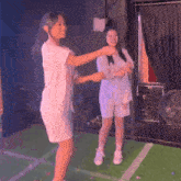 two women are dancing together in a dark room