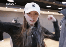 a woman wearing a white ny hat is dancing