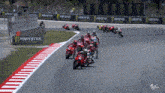 a group of motorcycle racers on a track with monster energy banners