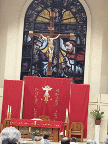 a stained glass window in a church shows jesus hanging on a cross