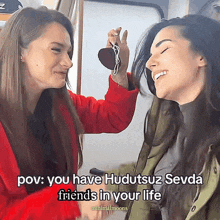 two women are laughing and one has a heart in her hand
