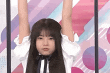 a young girl is hanging upside down with her arms up in the air .