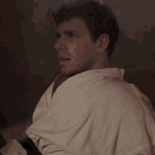 a man wearing a white robe is looking at something
