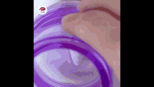 a close up of a person 's hand holding a purple bottle