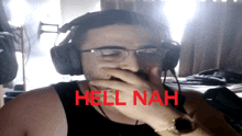 a man wearing headphones covering his mouth with his hand with the words hell nah written in red behind him