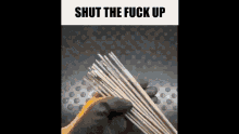 a person wearing a glove is holding a bunch of welding rods in their hand .