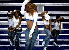 a group of young women are dancing in front of a bleachers .