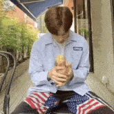 a man wearing a blue shirt with the word swag on it is holding a bag of food in his hands .