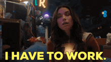 a woman in a superhero costume is sitting in a dark room and saying i have to work .