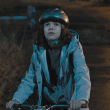 a young girl wearing a helmet and a jacket