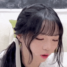 a close up of a girl 's face with a ponytail