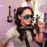 a woman wearing sunglasses and a party hat that says d on it