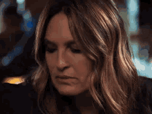 a close up of a woman 's face with long hair and a serious look on her face .
