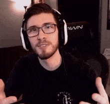 a man wearing glasses and headphones is standing in front of a chair that says awn