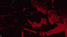 a man playing drums with a shirt that says " billy titan " on it