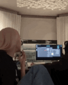 a woman sits in front of a computer screen that says ' ncr ' on it