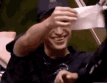 a man is holding a piece of paper in front of his face .