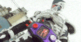 a person in a robot costume is holding a purple and red remote control .