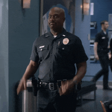 a police officer is standing in a hallway with his hands in his pockets and a badge on his uniform