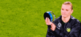a woman wearing a vw jacket holds a blue object in her hands