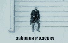 a man in a black coat is laying in the snow with the words " zabrali moderky " written below him