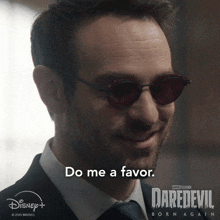 a man wearing sunglasses says " do me a favor " on a daredevil born again poster