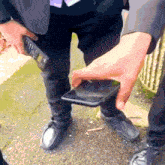 a man in a suit is holding a cell phone with the number 14 on it