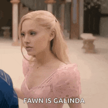 a woman in a pink dress is standing next to a man and says fawn is galinda .