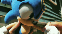 a sonic the hedgehog stuffed animal is being held by someone