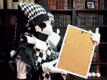 a harlequin is holding a picture frame in front of a bookcase