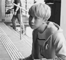 a young boy is sitting on a set of stairs looking at something .