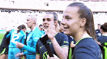 a group of female soccer players are standing on a field and one of them has the number 2 on her jersey