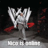 a man in a suit and tie is standing in front of a wrestling logo and says " nico is online "
