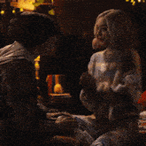 a man and a woman are kissing in a dark room with a lamp in the background .