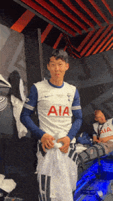 a soccer player in a white aia jersey
