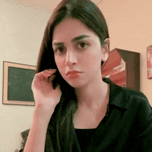 a young woman is talking on a cell phone in a room .