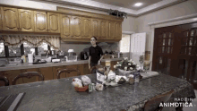 a woman stands in a kitchen next to a table that says made in animatica on it