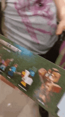 a person is holding a box of minecraft figures in their hands .