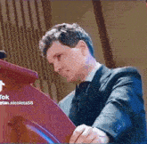 a man in a suit and tie is playing a piano in front of a podium .