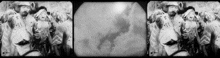 a black and white photo of a group of people standing in front of a cloudy sky