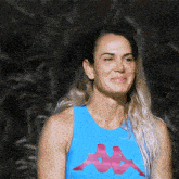 a woman wearing a blue kappa tank top