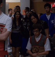 a group of people including a boy wearing glasses and a cheerleader with the letter c on his shirt