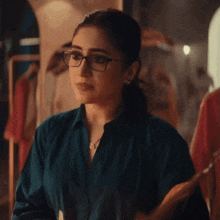 a woman wearing glasses is holding a hanger in her hands